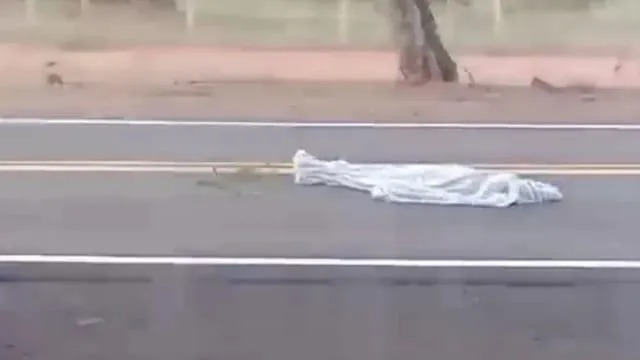 Corpo da vítima foi coberto por lençol, na pista da BR-262. - Foto: Princesinha News
